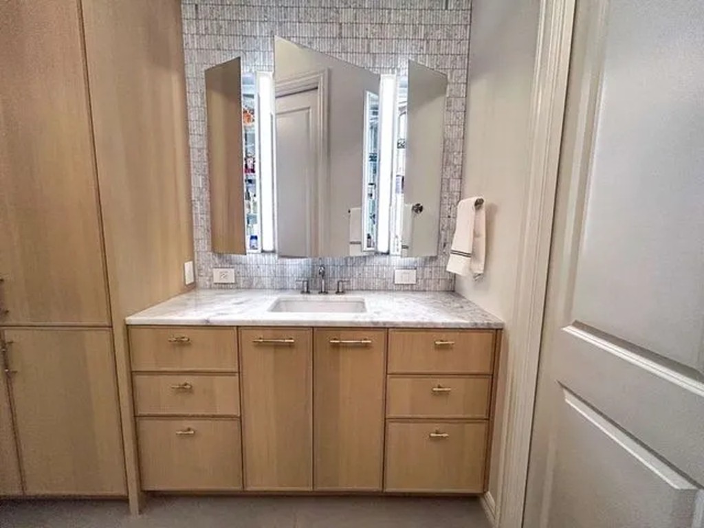 Marble shower walls with rain shower, handheld wand, and recessed niches