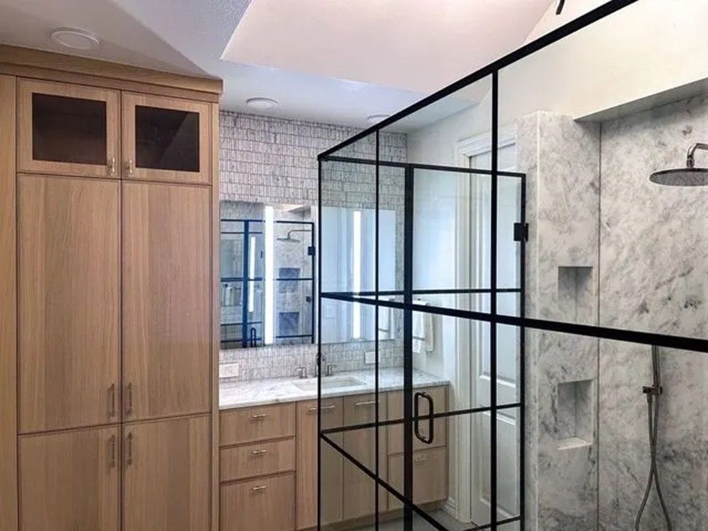 Shower interior with marble slabs, fixtures, and stacked tile niches