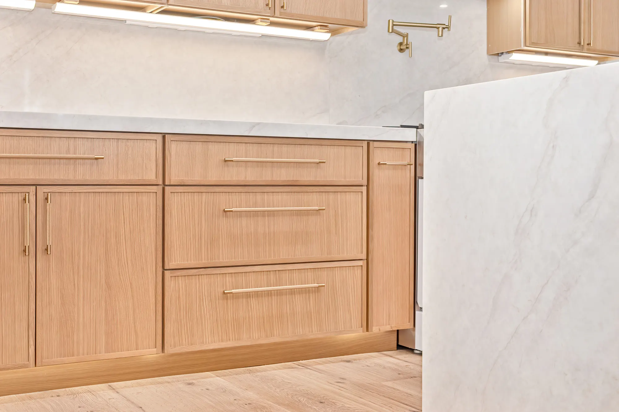 Custom oak cabinetry and marble waterfall counter detail