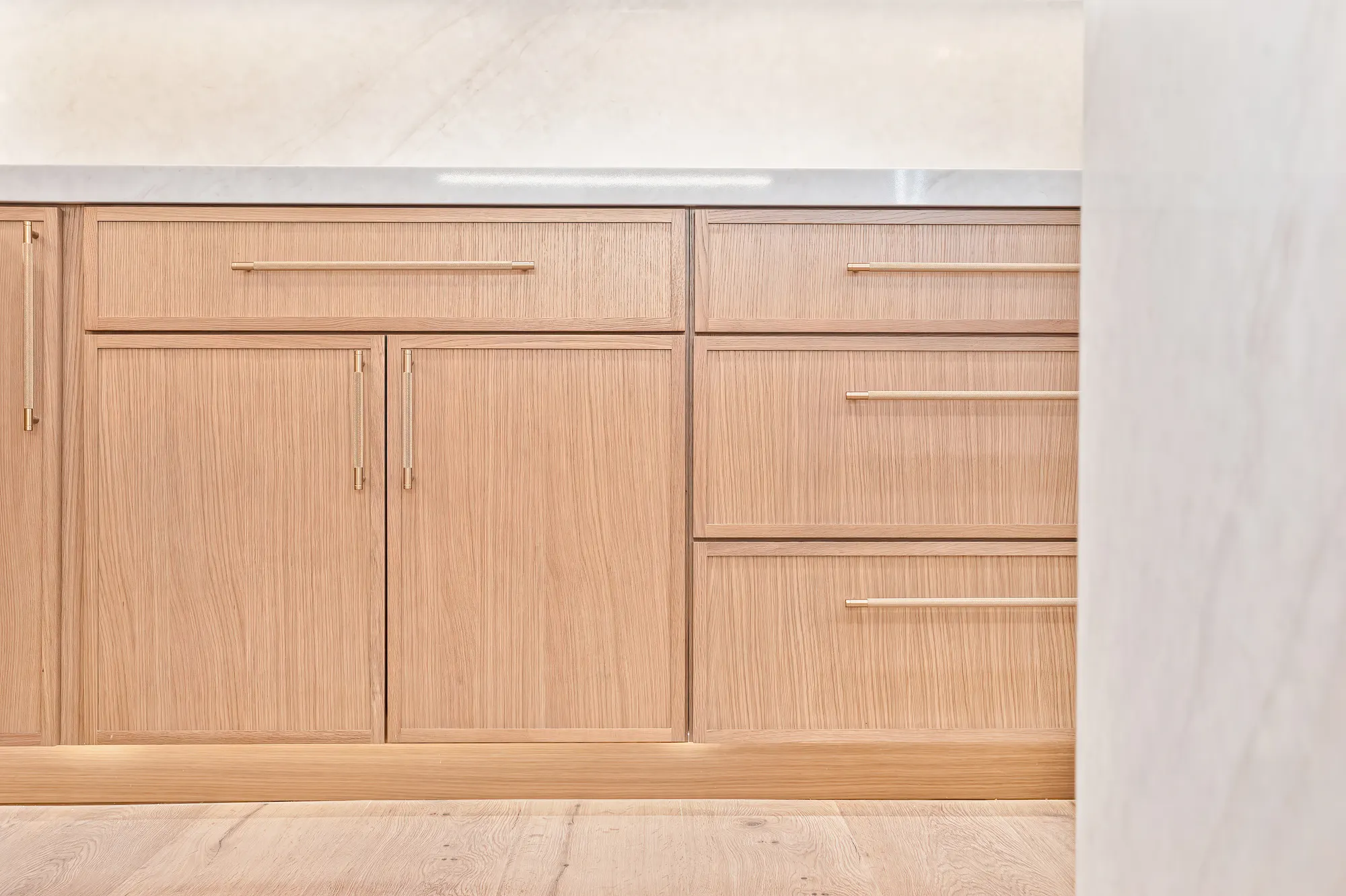 Custom oak cabinetry and marble waterfall counter detail